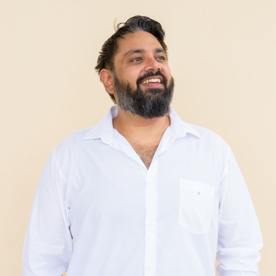 Portrait of handsome Indian man against plain background
