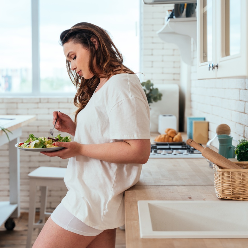 Lifestyle moments of a young woman at home. Woman preparing a salad in the kitchen