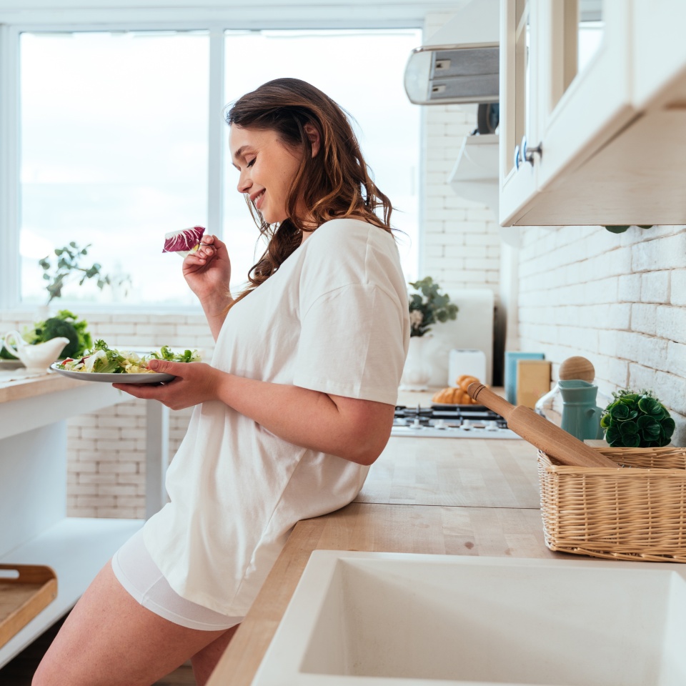 Lifestyle moments of a young woman at home. Woman preparing a salad in the kitchen