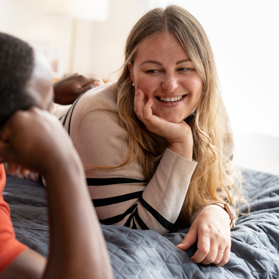 Romantic middle aged plus size woman lying on bed together with man at home. Relationship, love, lifestyle concept